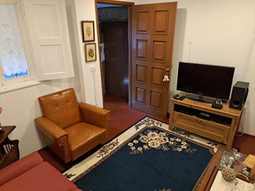 a living room with a chair and a television at Quinta da Lage Agroturismo e Enoturismo in Celorico de Basto