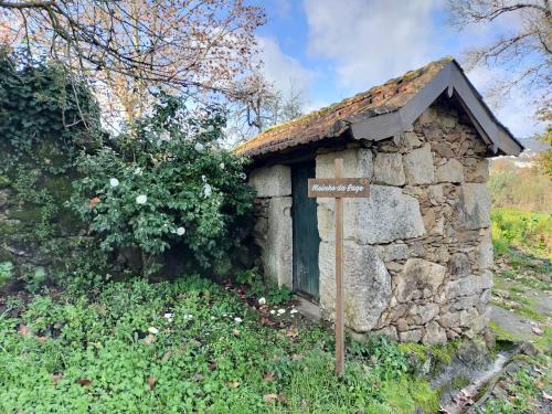a small stone building with a sign in front of it at Quinta da Lage Agroturismo e Enoturismo in Celorico de Basto