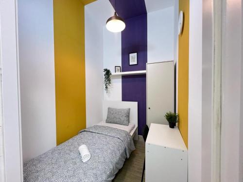 a bedroom with a bed and a yellow and white wall at Arch Partition Room Near Mall of the Emirates in Dubai