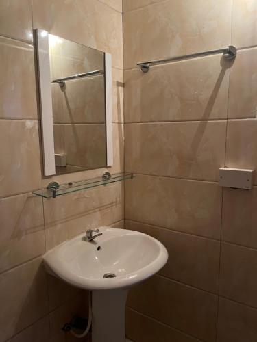 La salle de bains est pourvue d'un lavabo et d'un miroir. dans l'établissement Pearson Street, à Freetown