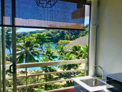 a kitchen with a window with a view of the ocean at Iaorana Tahiti in Arue