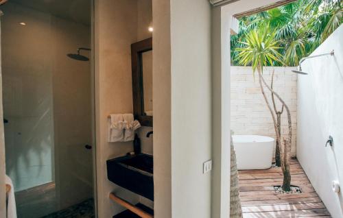 トゥルムにあるOrchid House Tulum Beachの部屋に洗面台と浴槽があるバスルーム