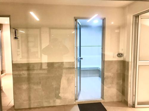 Una puerta de ducha de cristal en una habitación con en Gran departamento completamente amoblado en Quito
