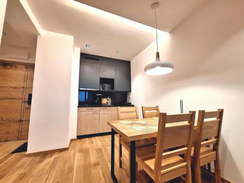 a kitchen and dining room with a table and chairs at Apartman Vuk, Apart hotel Zlatni javor in Jahorina