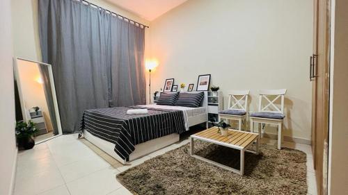 a bedroom with a bed and a table in it at Beautiful Bedroom in Al Barsha Near Mashreq Metro in Dubai