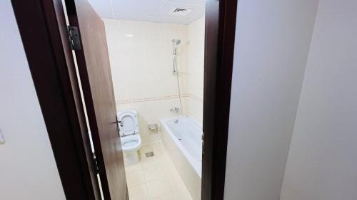 a bathroom with a toilet and a bath tub at Beautiful Bedroom in Al Barsha Near Mashreq Metro in Dubai