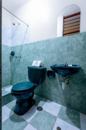 a bathroom with a blue toilet and a sink at Hotel Italia II in Chiclayo