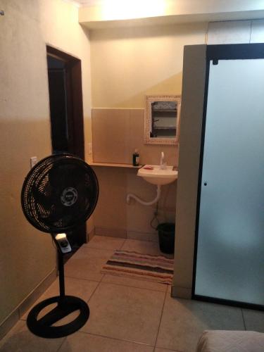 ein Bad mit einem Ventilator in der Ecke eines Zimmers in der Unterkunft Suíte o Pescador, praia do rosa in Garopaba