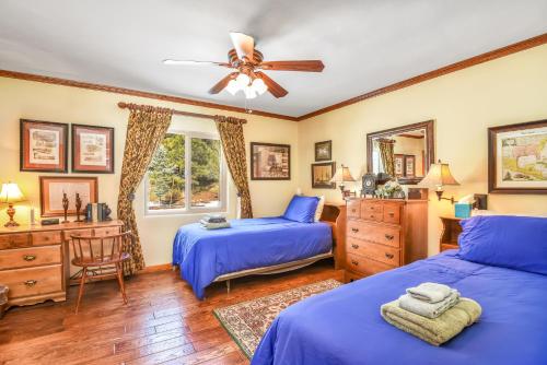 a bedroom with two beds and a ceiling fan at Relax in Frontier Retreat - Bordering Forest Service! in Flagstaff