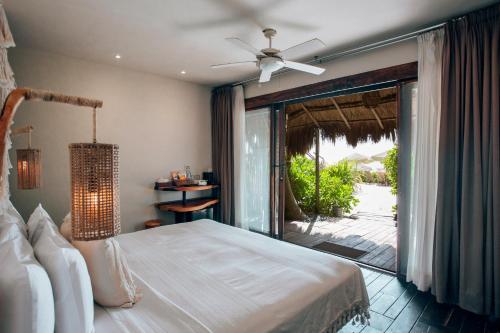 トゥルムにあるOrchid House Tulum Beachのベッドとガラスの引き戸のある寝室