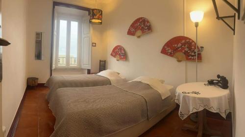 een kamer met 2 bedden, 2 tafels en een raam bij Peniche Hostel in Peniche