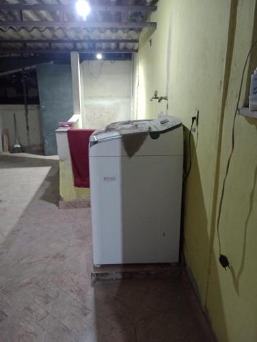 a white refrigerator sitting in a room with a wall at Casa Penha in Rio de Janeiro