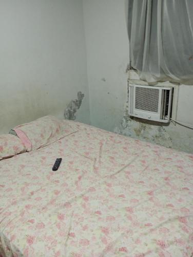 un gato sentado junto a una cama en un dormitorio en Casa Penha, en Río de Janeiro
