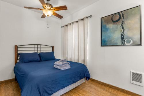 1 dormitorio con 1 cama con sábanas azules y ventilador de techo en Greenlaw Studio in the Pines! en Flagstaff