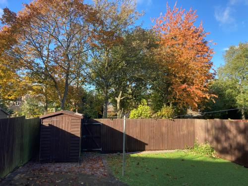 a backyard with a fence and a wooden at Watergall Lodge in Peterborough