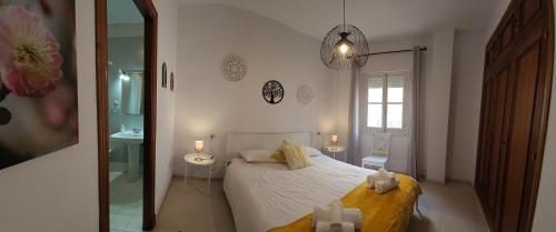 a bedroom with a bed and a bathroom with a mirror at CASA BLANCA-Parking gratis in Sanlúcar de Barrameda