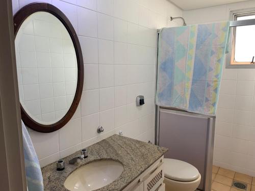 a bathroom with a sink and a mirror and a toilet at Apartamento no Centro para 7 pessoas in Campo Grande