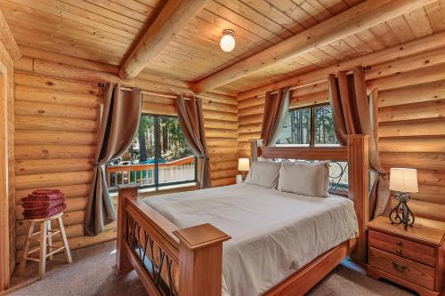 ein Schlafzimmer mit einem Bett in einer Blockhütte in der Unterkunft Lovely & Rustic TreeHouse Cabin - Stargazing in the Pines! in Mountainaire