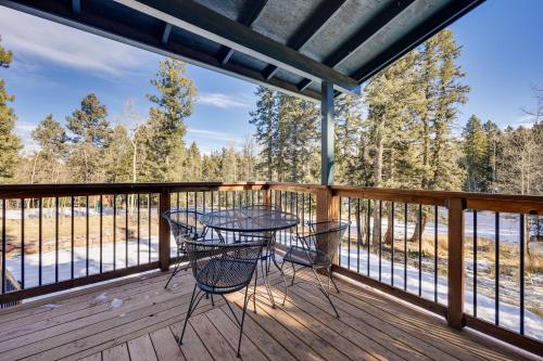 a patio with a table and chairs on a deck at Pet-Friendly Florissant Cabin with Fire Pit! in Florissant