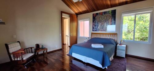 ein Schlafzimmer mit einem blauen Bett und einem Fenster in der Unterkunft Sossego, linda vista e muito verde a 45 min de SP in Cotia