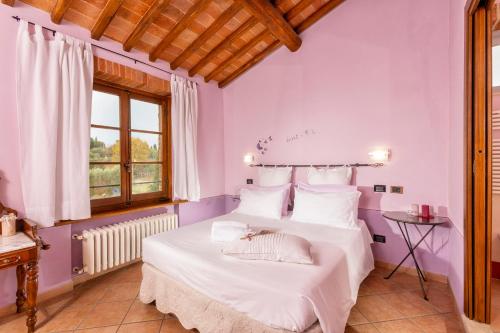 Schlafzimmer mit lila Wänden und einem Bett mit weißer Bettwäsche in der Unterkunft B&B La Casa di Assunta in Acquaviva