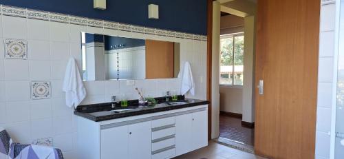 ein Bad mit einem Waschbecken und einem Spiegel in der Unterkunft Sossego, linda vista e muito verde a 45 min de SP in Cotia