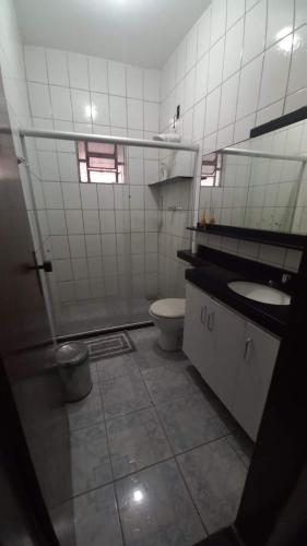 a bathroom with a toilet and a sink and a mirror at Casa Catuçaba in Marechal Deodoro
