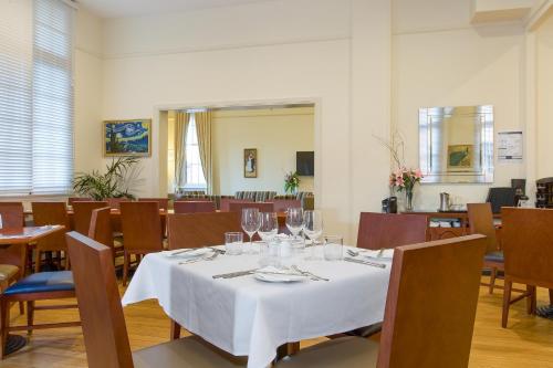 a dining room with a white table and chairs at Quality Hotel Regent Rockhampton in Rockhampton