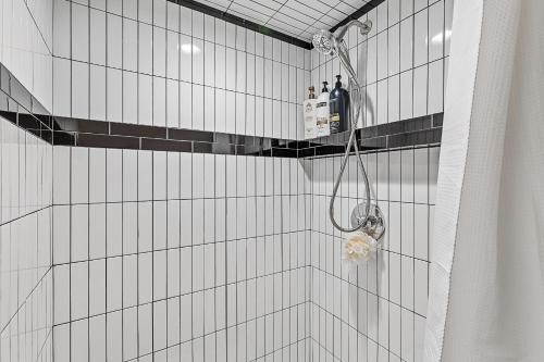 a shower with black and white tiled walls at Enchanting & Newly Built NoHo 1 BDR Loft with AC! in Flagstaff