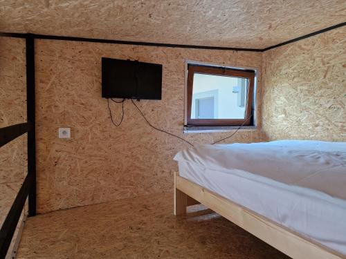a bedroom with a bed and a tv on the wall at Agroturystyka GRAMBURG in Zblewo