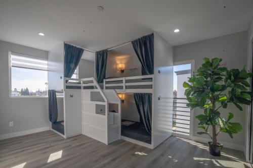 Normandie Hostel في لوس أنجلوس: غرفة نوم مع سرير بطابقين مع نبات الفخار