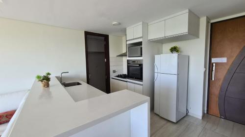 a white kitchen with a refrigerator and a sink at Luxury apartment in the most privileged area - SC in Santa Cruz de la Sierra