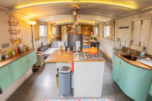 a kitchen with a table in the middle of a trailer at Off-Grid Living on Spacious Widebeam in Bath