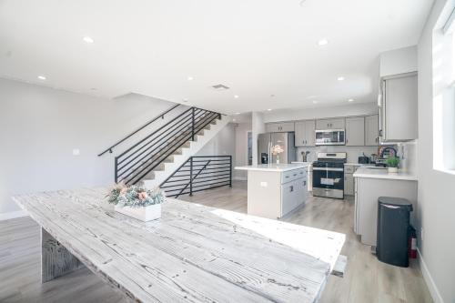 a kitchen with a wooden table and a staircase at Normandie Hostel in Los Angeles