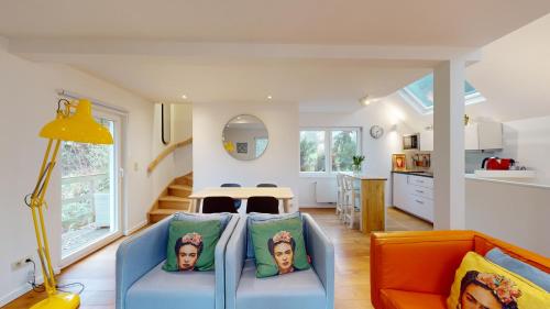 a living room with a blue couch and a kitchen at The Tile House - 2 bedroom property just south of Brussels in Sint-Genesius-Rode