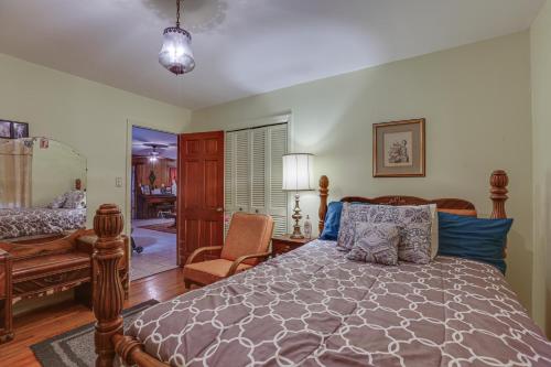 a bedroom with a bed and a desk and a chair at Rustic Thomasville Home with Deck 2 Mi to Downtown! in Thomasville