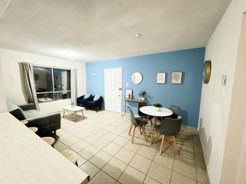 ein Wohnzimmer mit blauen Wänden sowie einem Tisch und Stühlen in der Unterkunft Depas & Suites JUAREZ in Ciudad Juárez