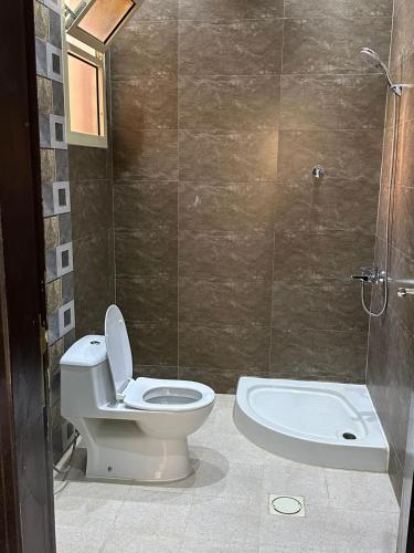 a bathroom with a toilet and a shower at Here we go in Riyadh