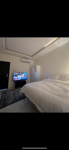 a bedroom with a bed and a flat screen tv at Here we go in Riyadh