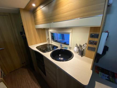 een badkamer met een wastafel in een kleine kamer bij RostrevorValley Caravan Experience Private HotTub in Rostrevor