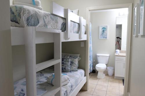a bedroom with two bunk beds and a bathroom at Laketown Wharf 1233 luxury condo in Panama City Beach