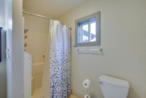 a bathroom with a toilet and a shower with a window at Cozy Oklahoma City Home with Deck and Gas Grill! in Oklahoma City