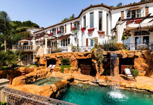 a pool in front of a house with a waterfall at Luxury Bel Air Villa Heated Pool Panoramic Views 6 Bedrooms in Los Angeles