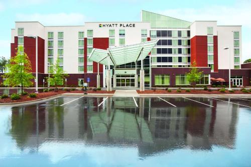 a building with a pool of water in front of it at Hyatt Place Raleigh Cary in Raleigh