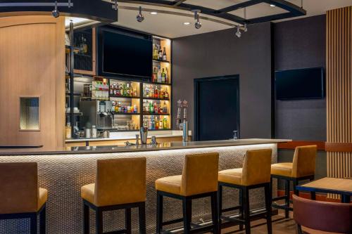 a bar in a restaurant with chairs and a counter at Hyatt Place Raleigh Cary in Raleigh