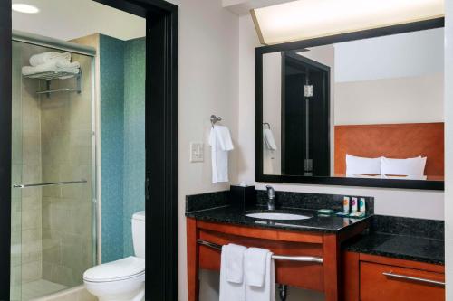 a bathroom with a sink and a toilet and a mirror at Hyatt Place Raleigh Cary in Raleigh