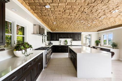 a kitchen with black cabinets and a stone ceiling at Luxury Bel Air Villa Heated Pool Panoramic Views 6 Bedrooms in Los Angeles