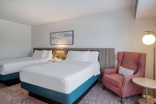 une chambre d'hôtel avec deux lits et une chaise dans l'établissement Hilton Garden Inn Clarksburg, à Clarksburg