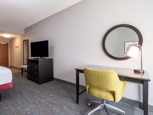 a hotel room with a desk and a mirror at Hampton Inn West Palm Beach-Florida Turnpike in West Palm Beach