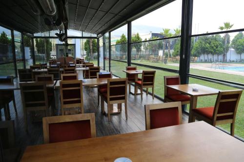 a row of tables and chairs in a restaurant with windows at Ramada By Wyndham Soma in Soma